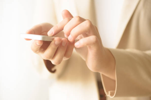 istock Woman hands hold cell phone on light cream background with copy space. Business, study, remote work, always connect concept. Smartphone 1003115146