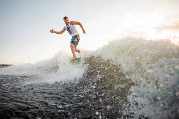 istock Athletic and young wakesurfer riding on river waves 1003115944