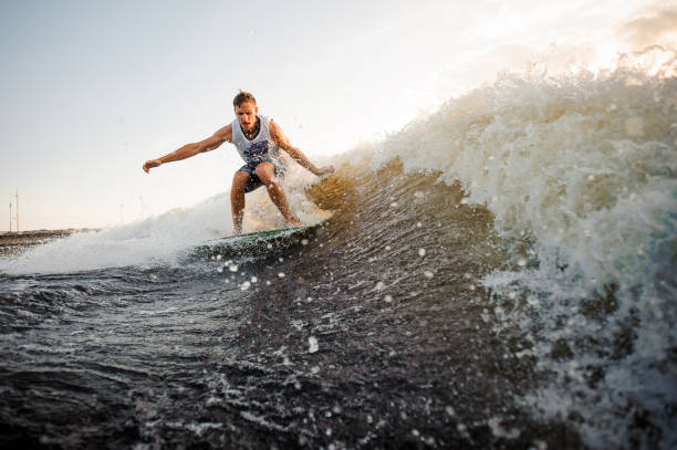 istock Strong and young wakesurfer riding on river waves 1003118570