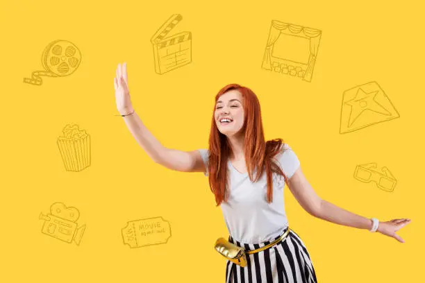 Photo of Young actress smiling and waving to her fans in a cinema