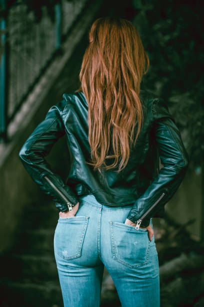 istock Sensual Female Standing Near Staircase With Hands In Pockets 1003119080