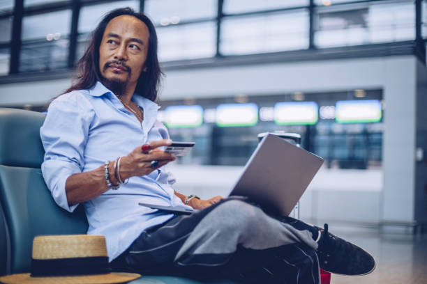 istock Man using laptop at the airport terminal 1003119652