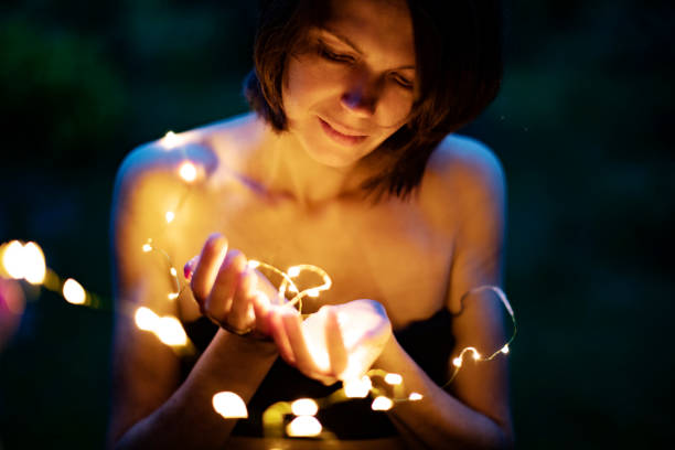 istock Christmas lights in woman hands 1003126432