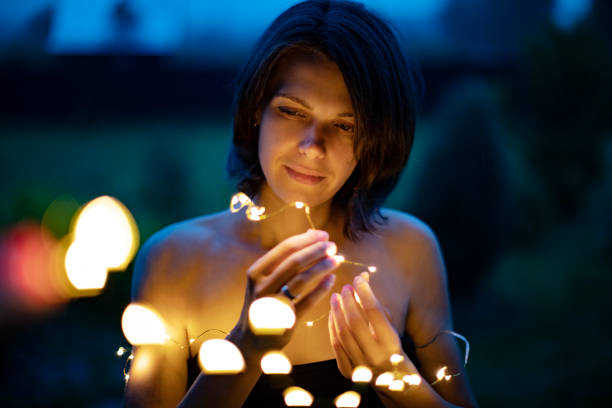 istock Christmas lights in woman hands 1003126580
