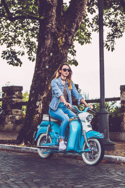 istock Young Woman Driving Old-fashioned Motor Scooter 1003127532