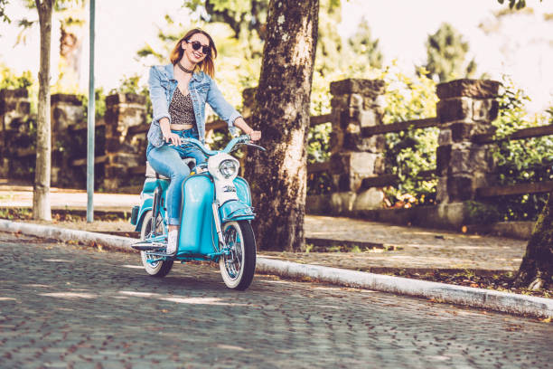 istock Smiling Young Woman Driving Old-fashioned Motor Scooter 1003127538