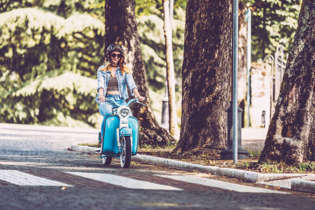 istock Smiling Young Woman Driving Old-fashioned Motor Scooter 1003127548