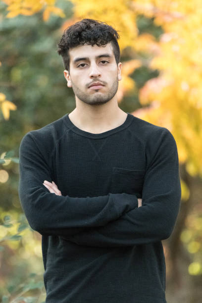 Serious young man Serious young man looking at the camera with his arms crossed iranian ethnicity stock pictures, royalty-free photos & images