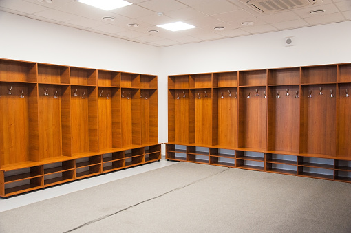 Wide view room shot of an empty hospital locker room, storage lockers are in a row with keys hanging in the locks at a hospital in Newcastle, England.