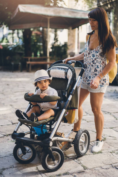 istock Mother with toddler sitting in baby stroller 1003150376