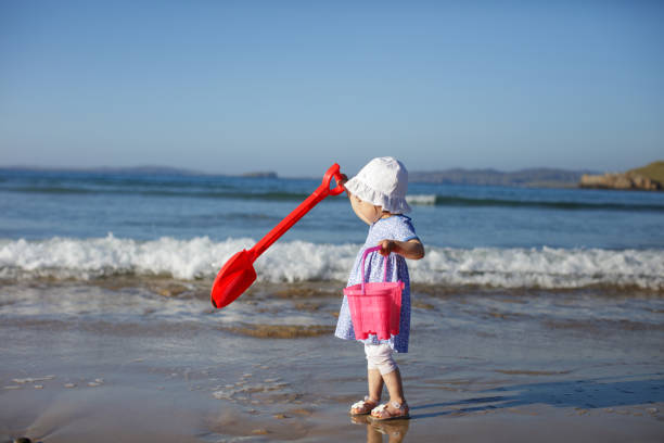 istock baby girl playing at summer beach 1003153444