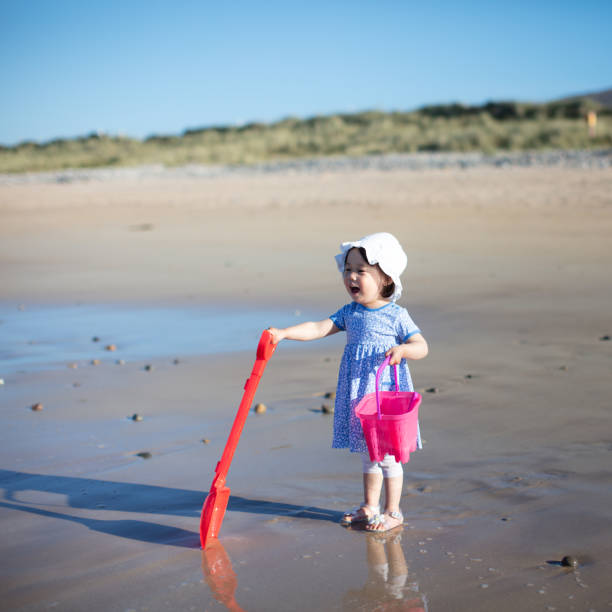 istock baby girl playing at summer beach 1003153472