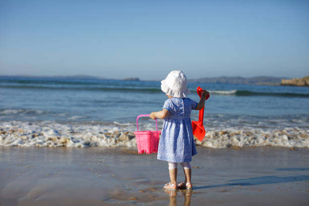 istock baby girl playing at summer beach 1003153486