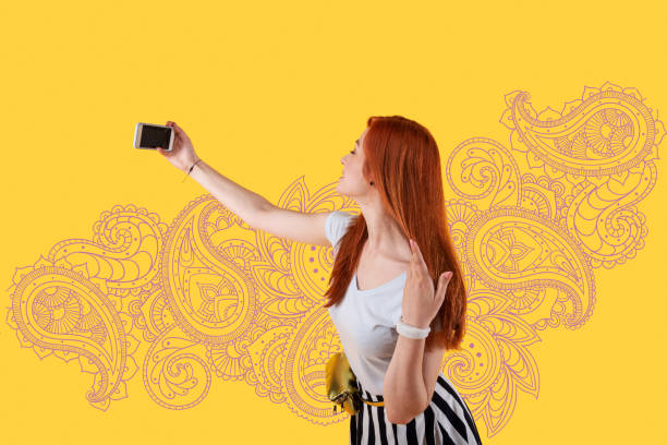 istock Cute young person touching her hair while taking a selfie 1003153584