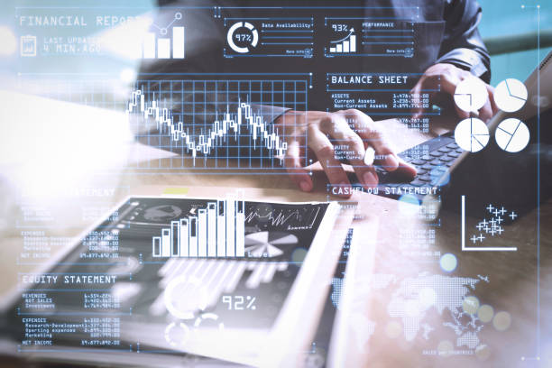 istock Businessman hand working concept. Documents finance graphic chart. Digital tablet keyboard dock screen computer design smart phone using. Eyeglass on marble desk. Sun flare effect 1003154070