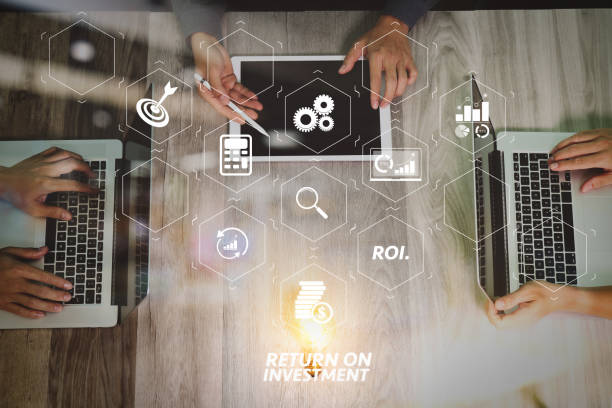 ROI Return on Investment indicator in virtual dashboard for improving business. Team business meeting presentation. Hand businessman working new start up project in modern office. presentación de reunión de negocio de equipo. empresario de la mano trabajando nuevo comienzo proyecto en oficina moderna. ordenador portátil, mesa digital y teléfono inteligente en la mesa de madera. vista superior, foto de efecto de llamarada de sol