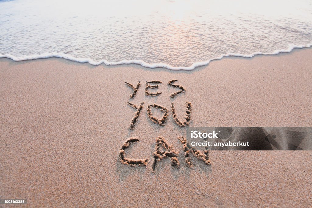 sí se puede, motivacional inspirador mensaje sobre la arena - Foto de stock de Motivación libre de derechos