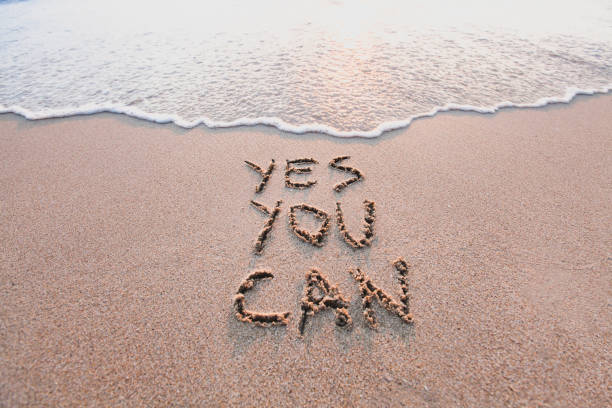 sì, puoi, messaggio motivazionale ispiratore sulla sabbia - buoni propositi foto e immagini stock