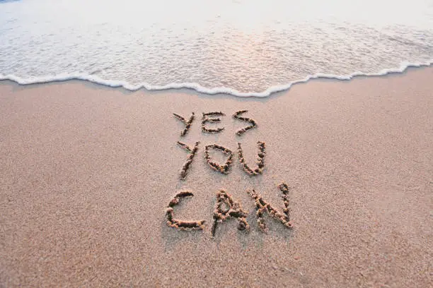 Photo of yes you can, motivational inspirational message on sand