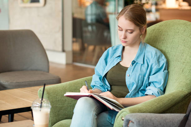 istock attractive 20 year old woman draws in a sketchbook 1003182386