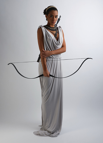 African American woman with bow and arrow wearing Grecian style dress