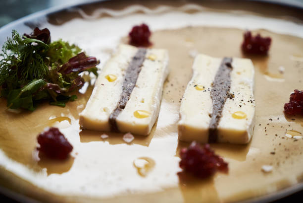 Brie cheese with truffle and jelly barberry. Delicious dish with champignons mushrooms and truffle oil at the restaurant table. Vegetarian delicacy diet food