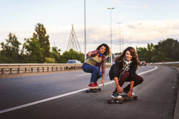 istock Skateboard girls riding longboards down the road 1003190184