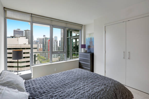 Grey bedroom in modern apartment with private balcony.