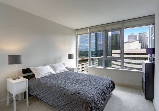 istock Grey bedroom in modern apartment with private balcony. 1003196274