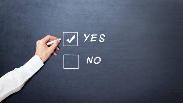 hand chooses between yes and no with chalk on the blackboard