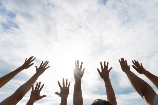 istock Many hands raised up against the blue sky. Friendship, Teamwork concept. 1003225410