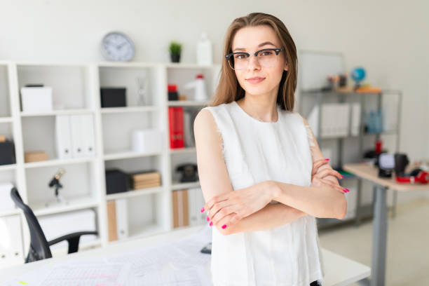 istock young girl in an office is standing near a table. 1003236044