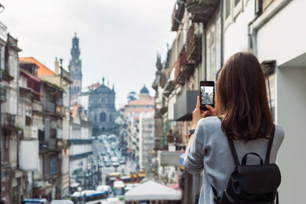 Young traveler woman taking a photo with her phone in Porto, Portugal stock photo