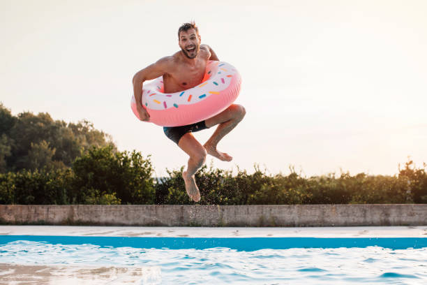 un saut avec anneau gonflable - swim ring photos et images de collection