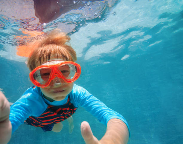 istock little boy swimming underwater 1003249026