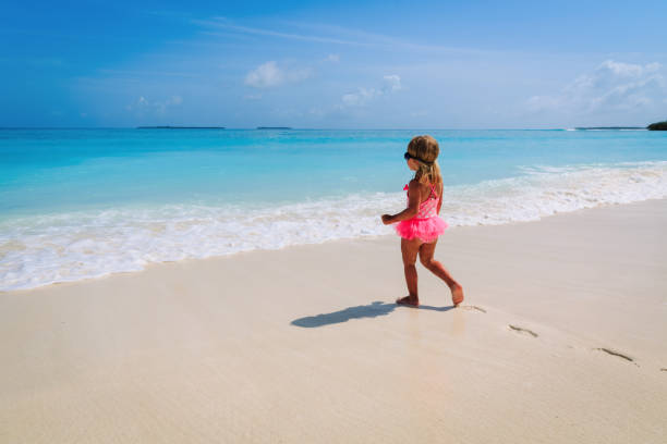 istock little girl going to swim at beach 1003249434