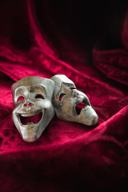 istock Theater masks over red curtain / 3D rendering 1003254772