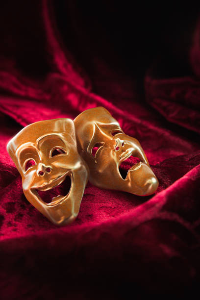 istock Theater masks over red curtain / 3D rendering 1003257070