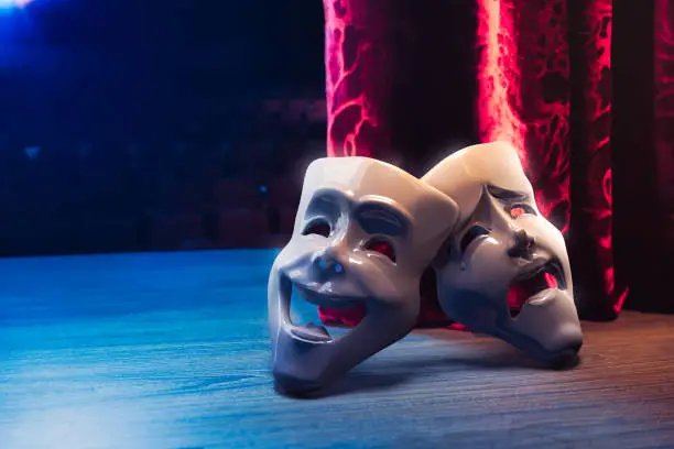 Photo of Theater masks in front of a red curtain/ 3D rendering