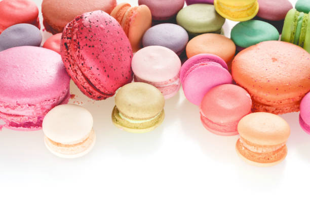 istock Mixed size of french macarons on white background with copy space . 1003257538