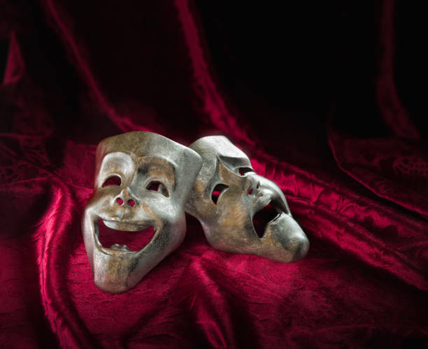 istock Theater masks over red curtain / 3D rendering 1003259874