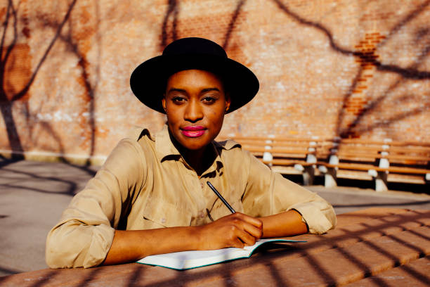 istock Female writer writing outside, looking at camera 1003269724