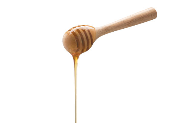 istock Organic Honey with wooden spoon on white background 1003272246