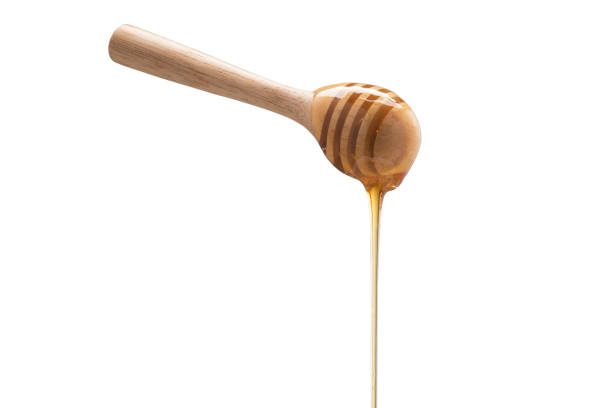 istock Organic Honey with wooden spoon on white background 1003272248
