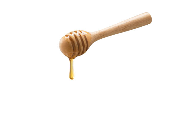 istock Organic Honey with wooden spoon on white background 1003272258