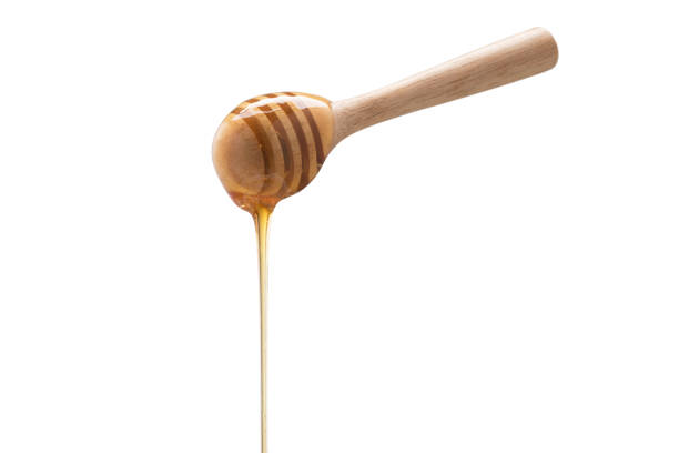 istock Organic Honey with wooden spoon on white background 1003272292