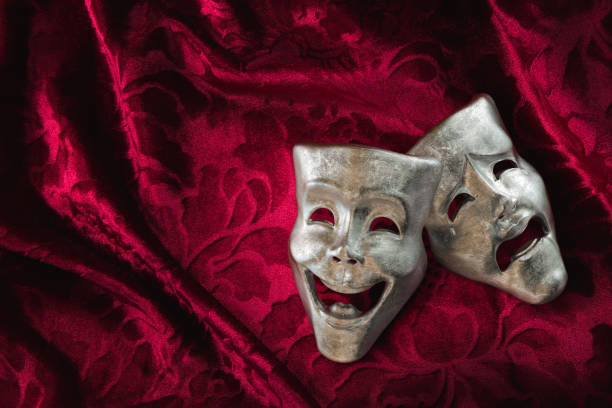 istock Theater masks over red curtain / 3D rendering 1003278188