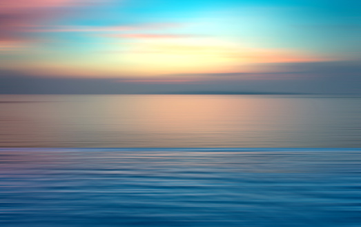Motion blurred background of refraction in water. Panoramic dramatic view of Infinity sunset on the sea at twilight times