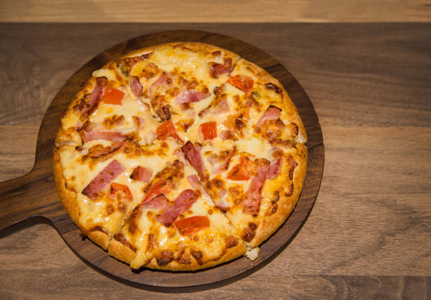 istock hot pizza on wood plate for dinner from top view 1003286204