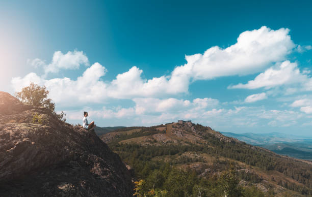 woman photographer takes a picture of a mountain landscape on the camera stock photo